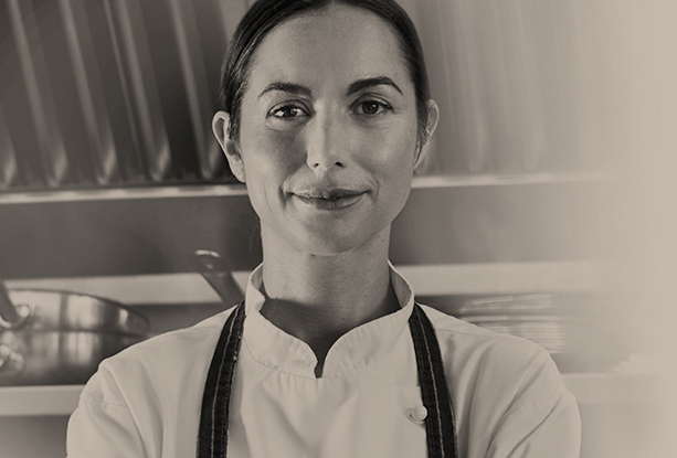 A female chef in the kitchen smiling